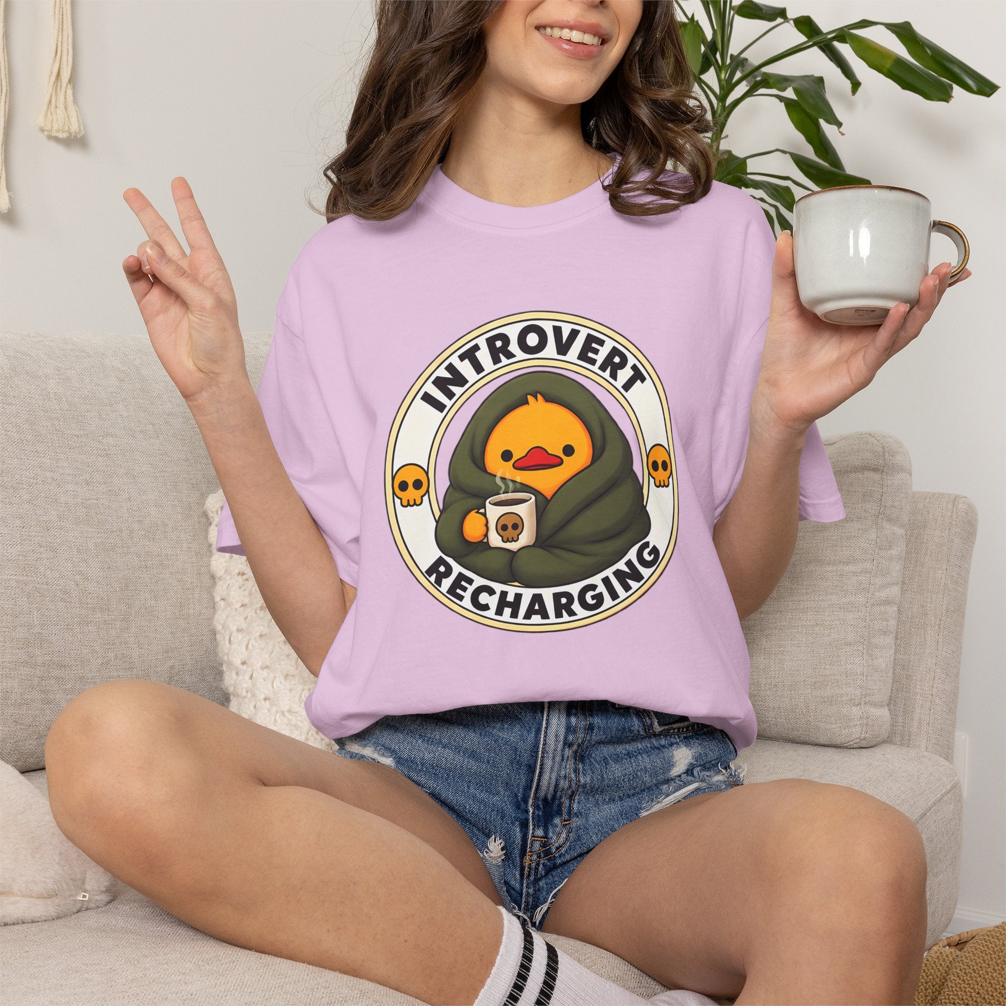 Woman wearing the Introvert Duck Tee in Orchid, lifestyle photo holding a mug