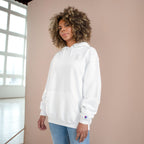 Woman wearing the white SparkyCA Champion hoodie beside a sunlit window