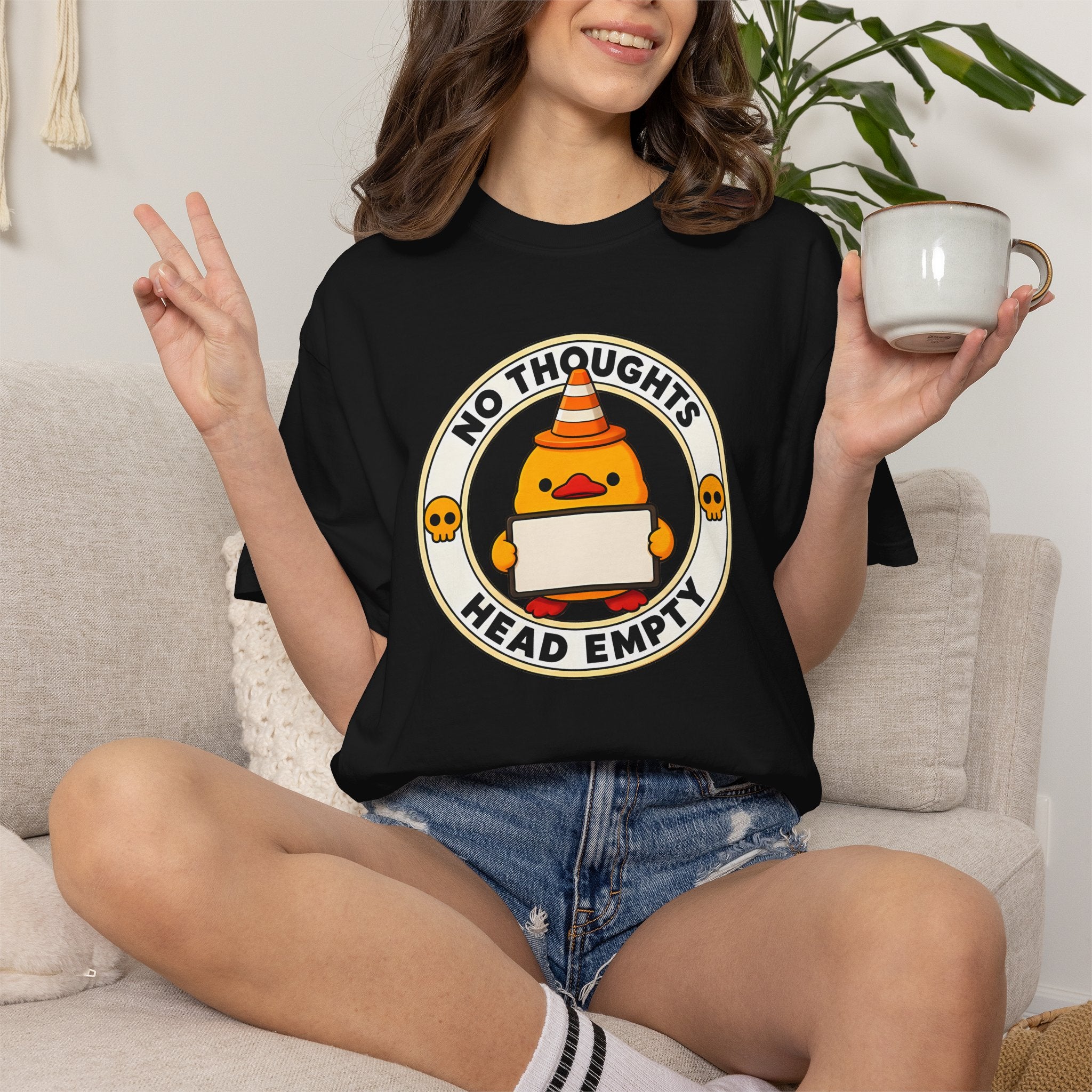 Woman wearing the No Thoughts Head Empty Duck Tee in Black, lifestyle photo holding a mug