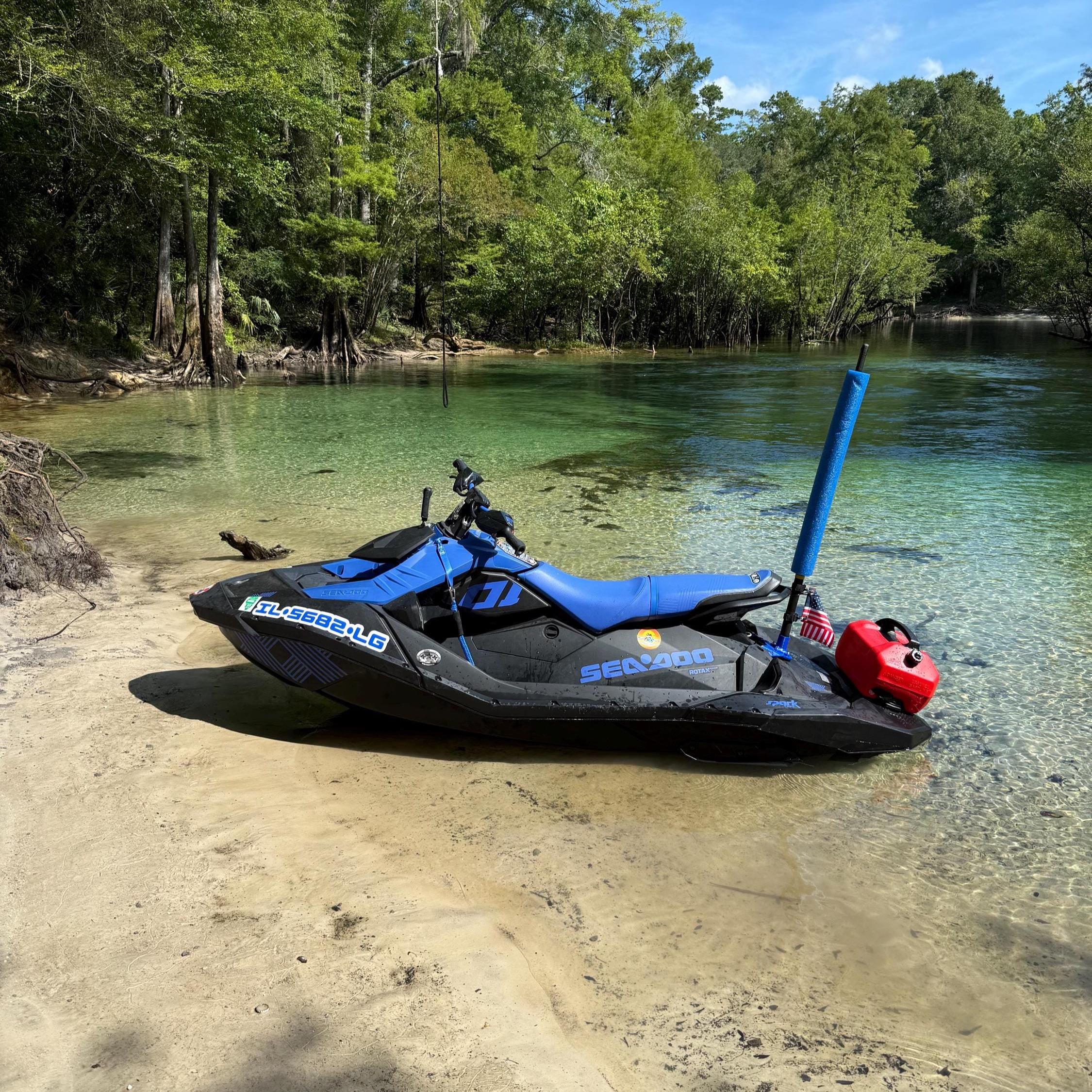 Sea-Doo Spark parked on a sandy shoreline with the flag pole and mount installed at the rear, gas can and US flag attached