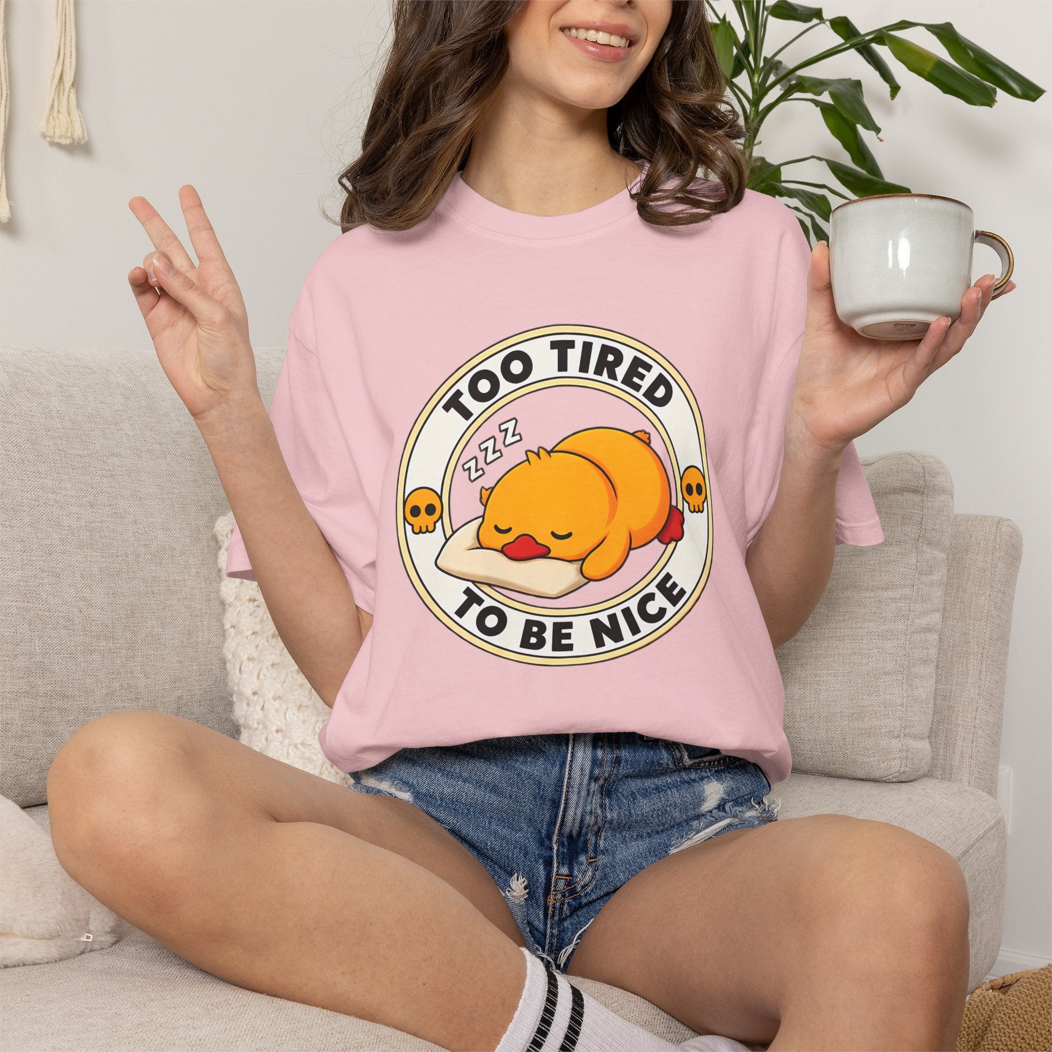 Woman wearing the Too Tired Duck Tee in Blossom, lifestyle photo holding a mug