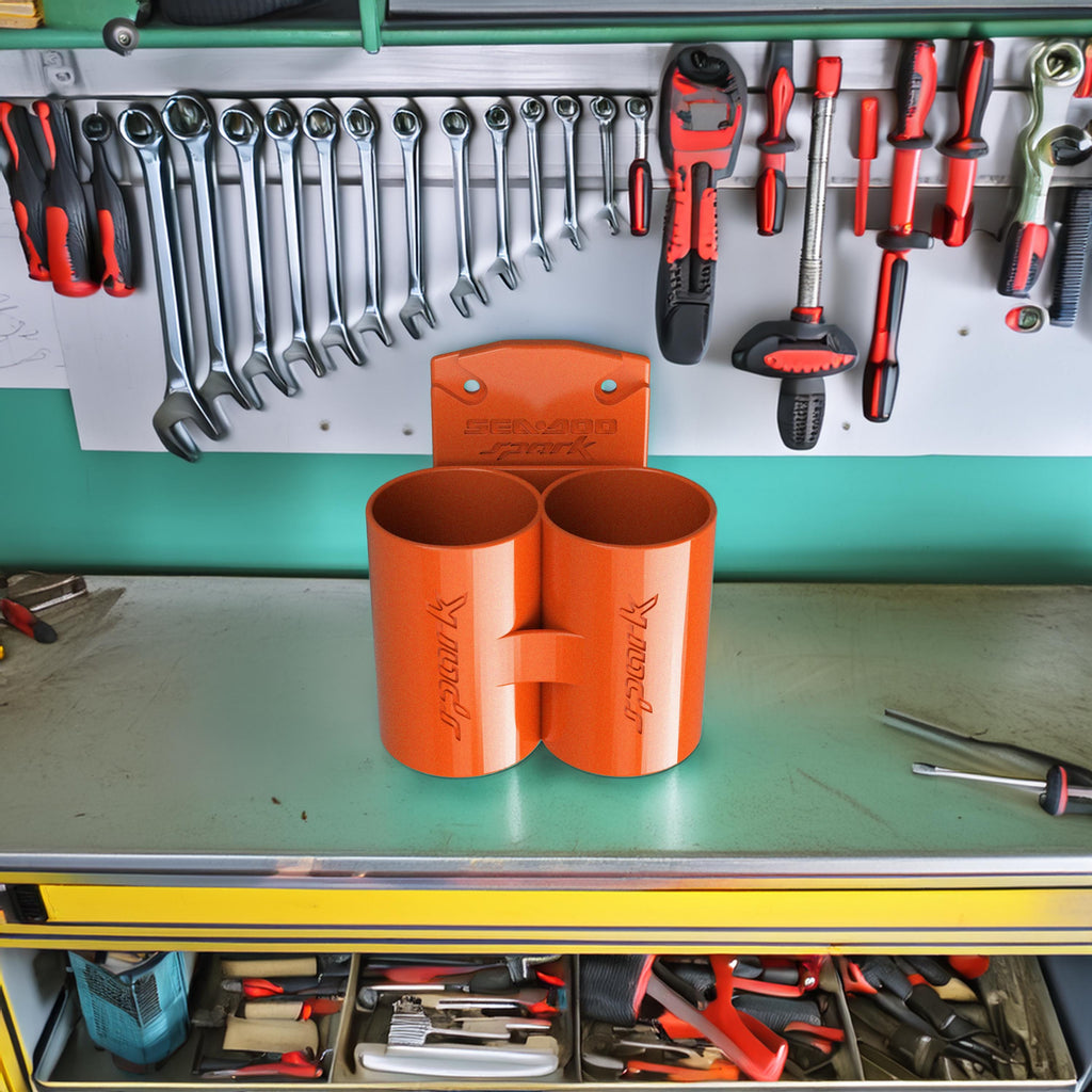 Orange Sea-Doo Spark Trixx cup holder displayed on a workbench with tools