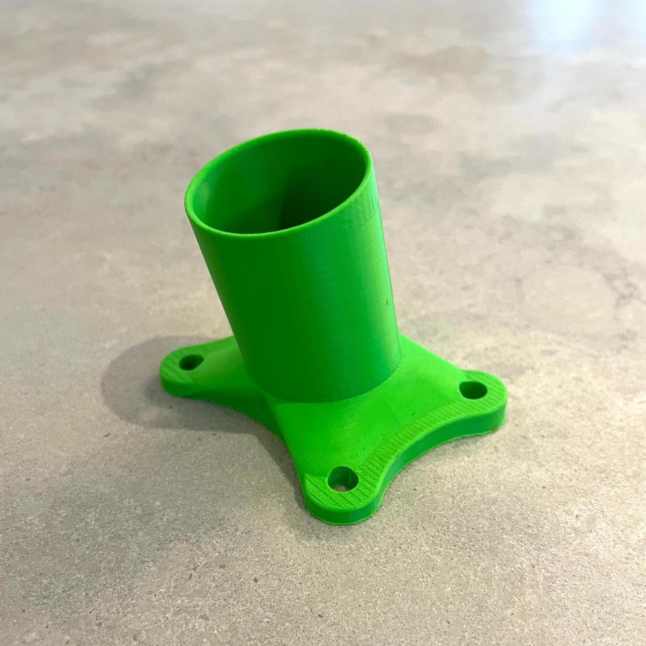 3D-printed flag/camera mount in green plastic, standalone photo on a countertop