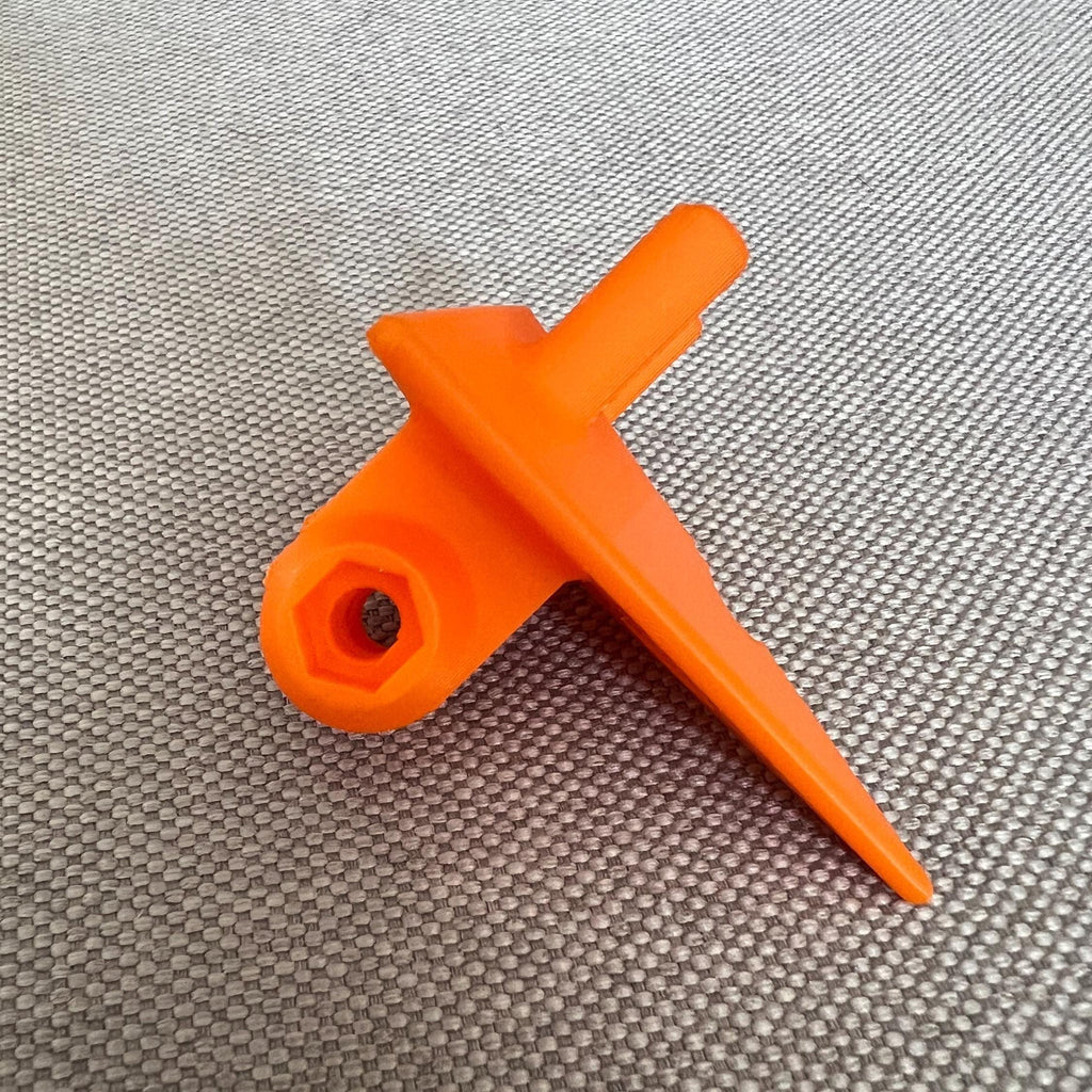 Orange 3D-printed GoPro mount on a woven fabric surface, top-down view