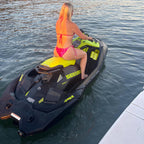 Yellow Sea-Doo Spark Trixx cup holder mounted on the rear deck, rider seated at the dock at sunset