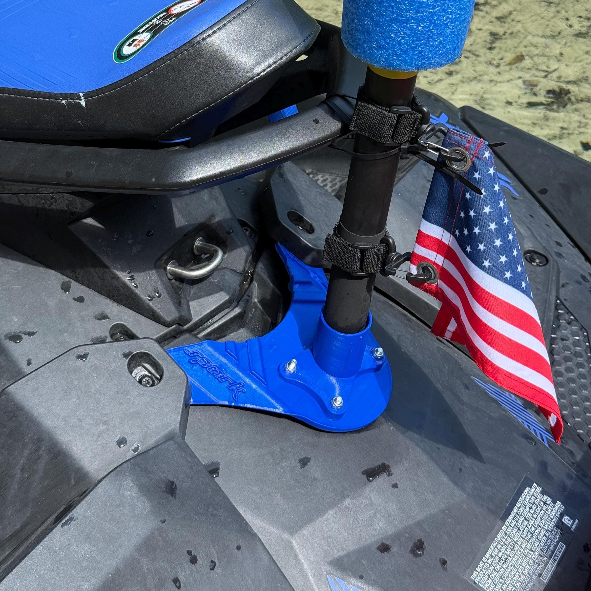 Close-up of the mount installed near the seat with a pole secured by straps and a US flag attached