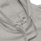 Close-up of the Carbon Grey hoodie's inner neck label showing the SparkyCA Designs logo, size, and made-in-Pakistan fabric tag