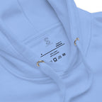 Close-up of the Carolina Blue hoodie's inner neck label showing the SparkyCA Designs logo, size, and made-in-Pakistan fabric tag