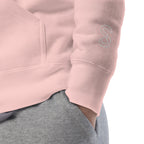 Close-up of the Light Pink hoodie's inner neck label showing the SparkyCA Designs logo, size, and made-in-Pakistan fabric tag