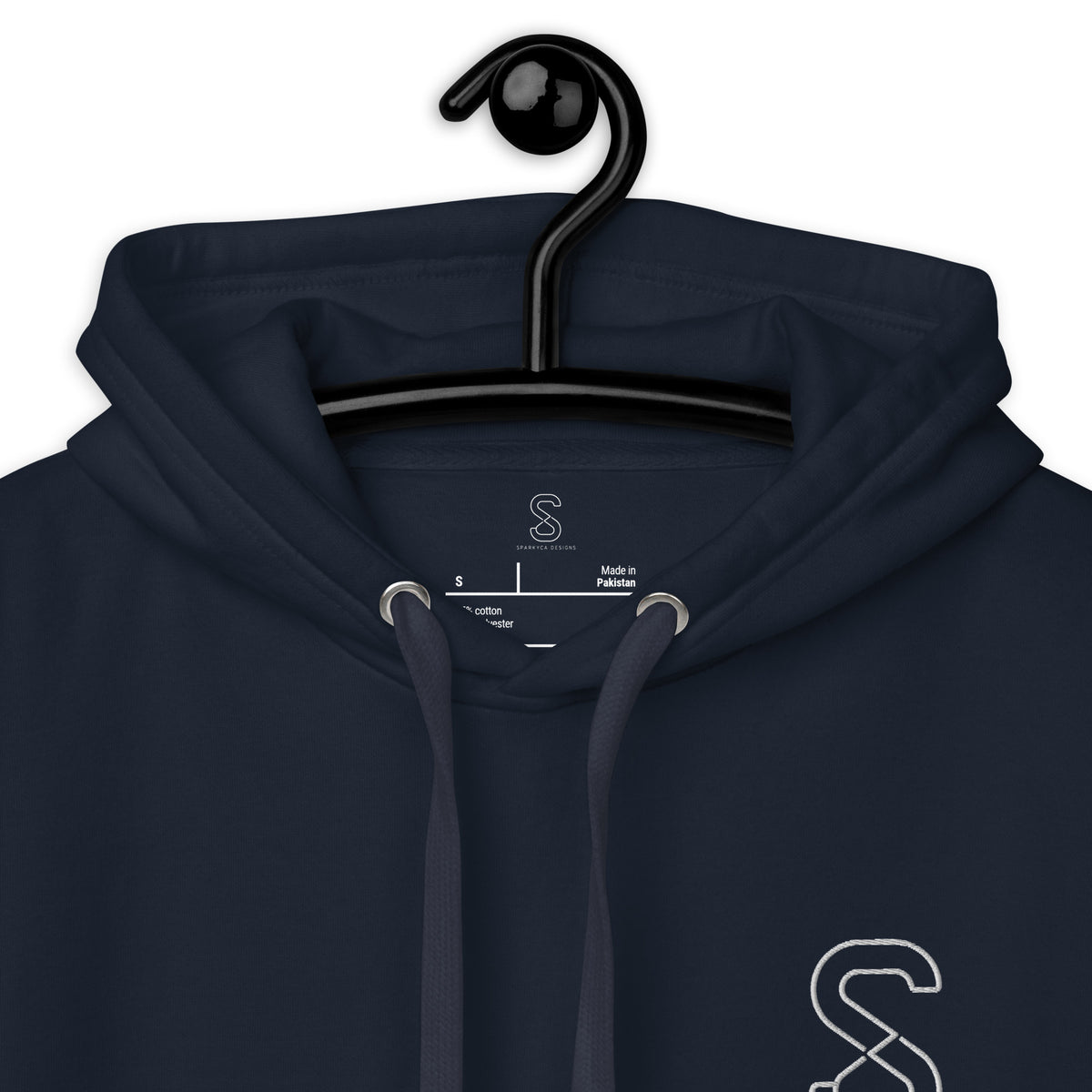 Close-up of the Navy Blazer hoodie's inner neck label showing the SparkyCA Designs logo, size, and made-in-Pakistan fabric tag