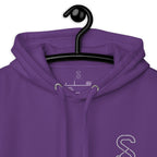 Close-up of the purple hoodie's inner neck label showing the SparkyCA Designs logo, size, and made-in-Pakistan fabric tag